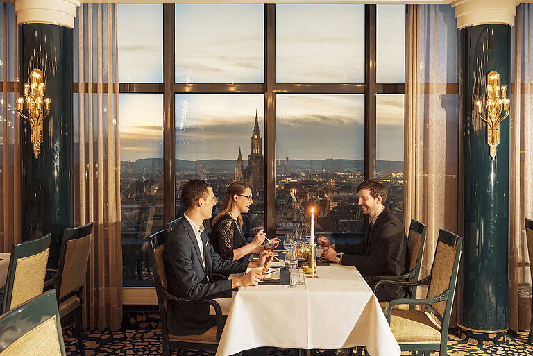 Gäste beim Abendessen mit Blick auf das Ulmer Münster im Restaurant des Maritim Hotel Ulm