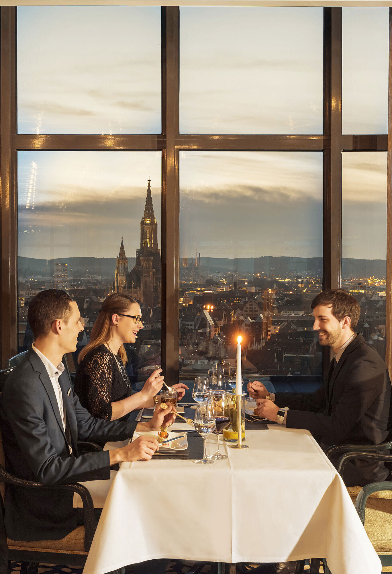 Gäste beim Abendessen mit Blick auf das Ulmer Münster im Restaurant des Maritim Hotel Ulm
