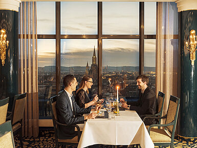 Gäste beim Abendessen mit Blick auf das Ulmer Münster im Restaurant des Maritim Hotel Ulm