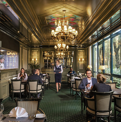  Gäste im eleganten Restaurant L'Echalote des Maritim Hotels Bremen genießen feine Speisen in stilvollem Ambiente.