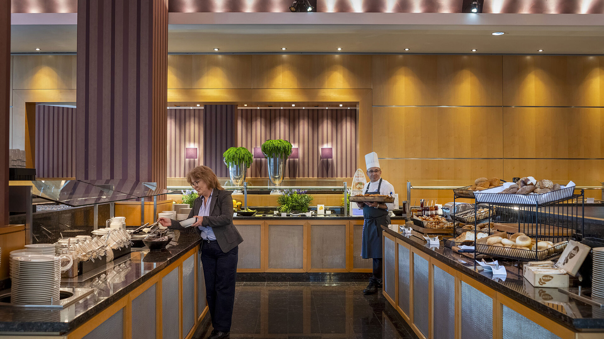 Restaurant Classico Frühstücksbuffet im Maritim Hotel Düsseldorf mit frisch gebackenem Brot, warmen Speisen und einer Köchin, die Gäste bedient.