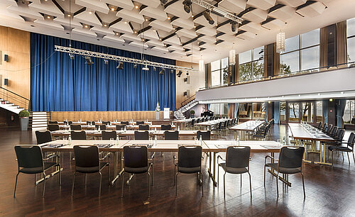 Großer Saal „Maritim“ im Maritim Seehotel Timmendorfer Strand mit Bühne, blauen Vorhängen und Bestuhlung für Tagungen.