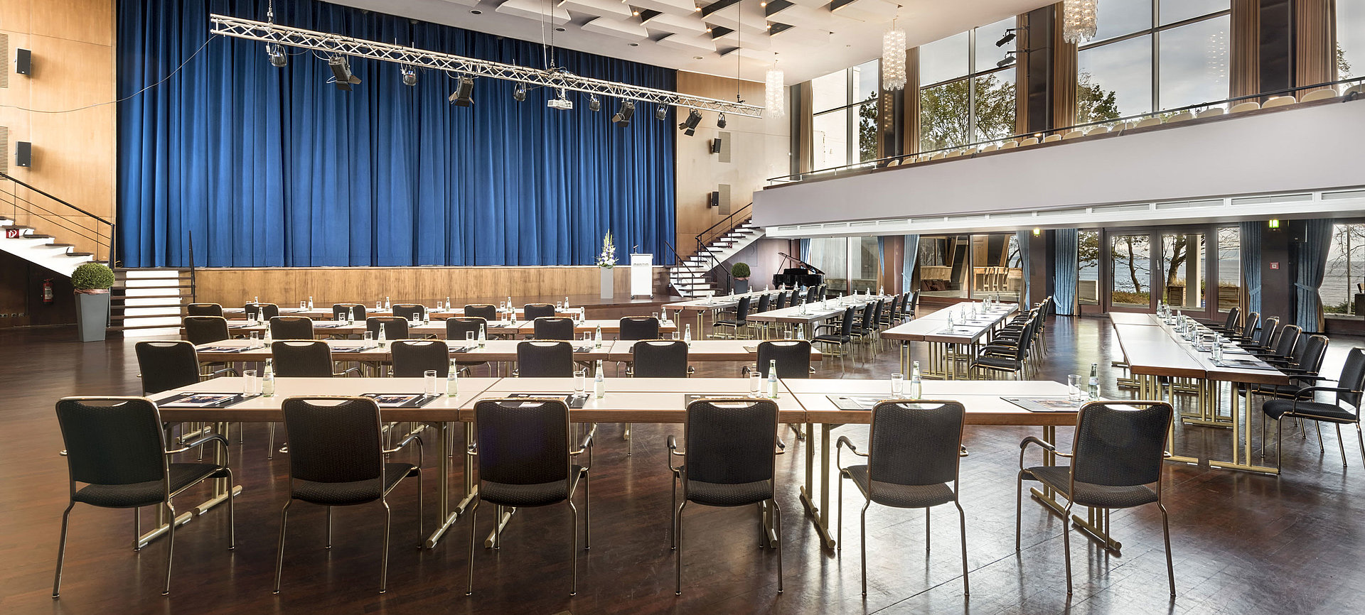 Großer Saal „Maritim“ im Maritim Seehotel Timmendorfer Strand mit Bühne, blauen Vorhängen und Bestuhlung für Tagungen.