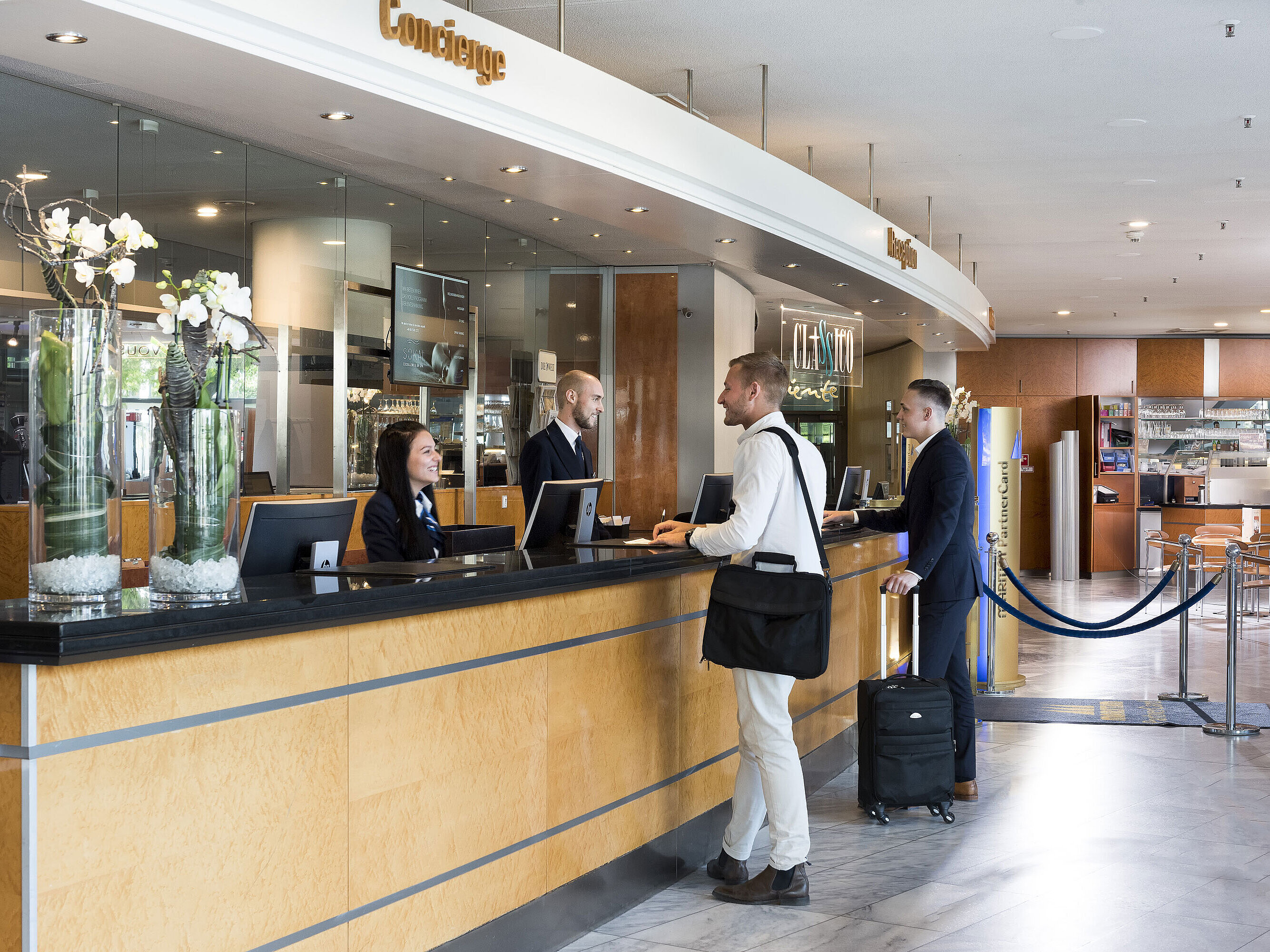 Freundlicher Empfang an der Rezeption des Maritim Hotel Frankfurt mit Gästen und Mitarbeitern in moderner Lobby.