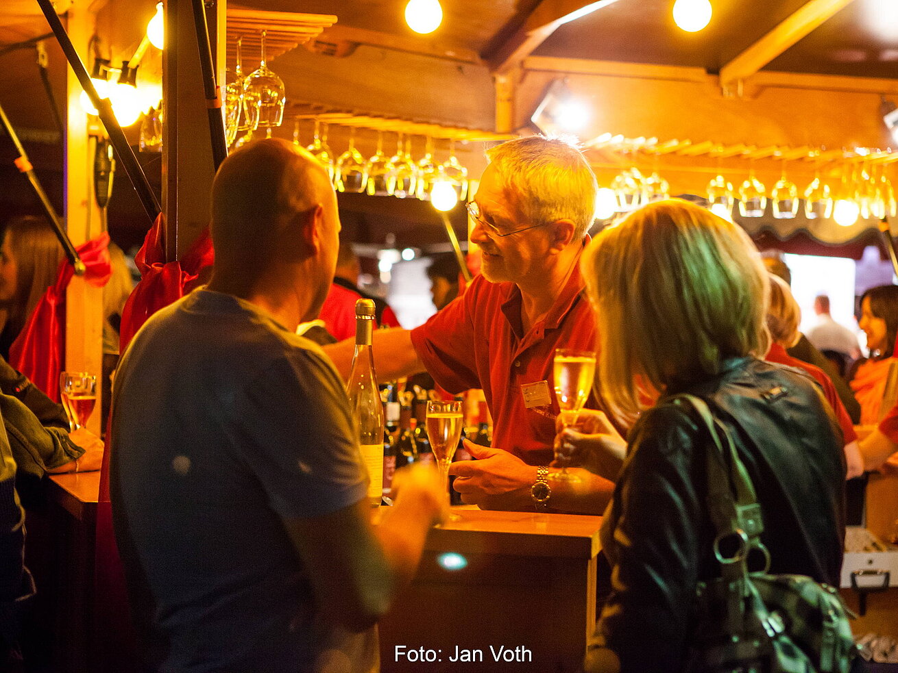 Weinfest Bad Salzuflen Besucher genießen das Weinfest in Bad Salzuflen mit beleuchteten Ständen und geselliger Atmosphäre.