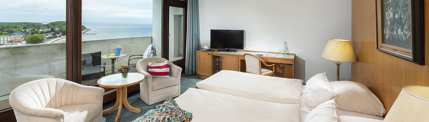 Komfortables Zimmer mit zwei Sesseln und Balkon mit Meerblick im Maritim Hotel Travemünde