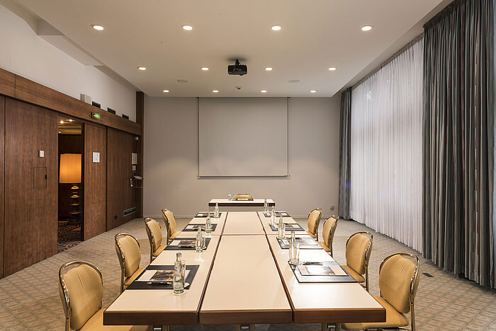 Konferenzraum „Salon Bonn“ im Maritim Seehotel Timmendorfer Strand mit Besprechungstisch,Tageslicht und Präsentationsleinwand