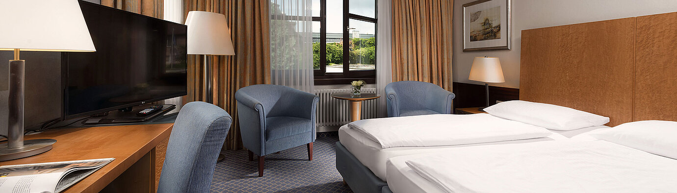 Classic Zimmer im Maritim Hotel Fulda mit gemütlichem Doppelbett, Schreibtisch, Sitzbereich und großem Fenster.