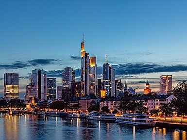 Skyline von Frankfurt am Main Blick über den Main auf die beleuchtete Skyline von Frankfurt am Main in der Abenddämmerung.