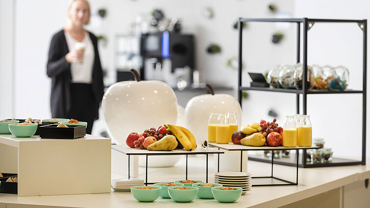 Tagungspause im Maritim Hotel Frankfurt mit gesunden Snacks, frischem Obst und Saft in entspannter Lounge-Atmosphäre.