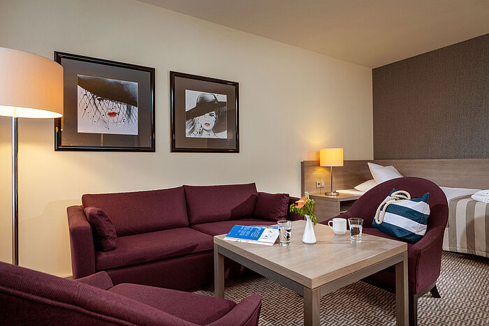 Gemütliche Sitzecke im Classic Familienzimmer des Maritim Hotel Königswinter mit Sofa, Sesseln und Couchtisch.