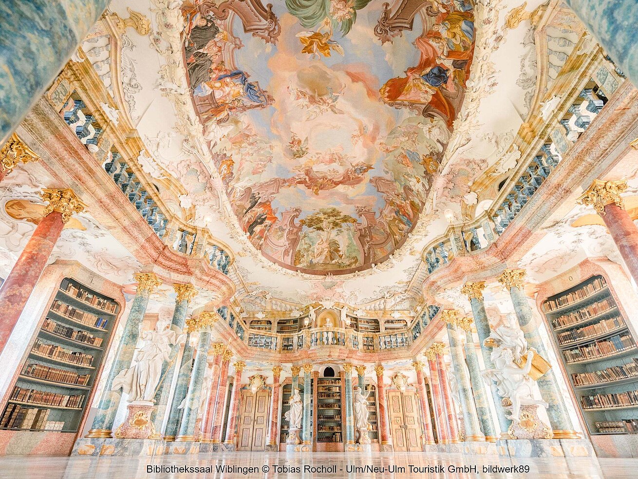 Prunkvoller Bibliothekssaal im Kloster Wiblingen mit kunstvoller Deckenmalerei und barocker Ausstattung.