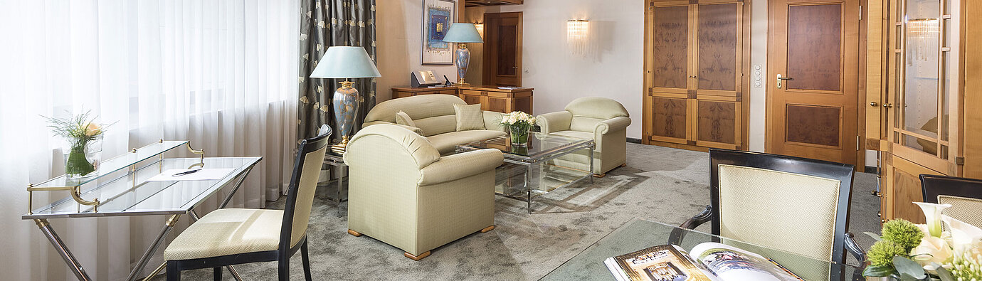 Großzügige Suite mit eleganter Einrichtung, Glastisch und gemütlicher Sitzgruppe im Maritim Hotel Magdeburg