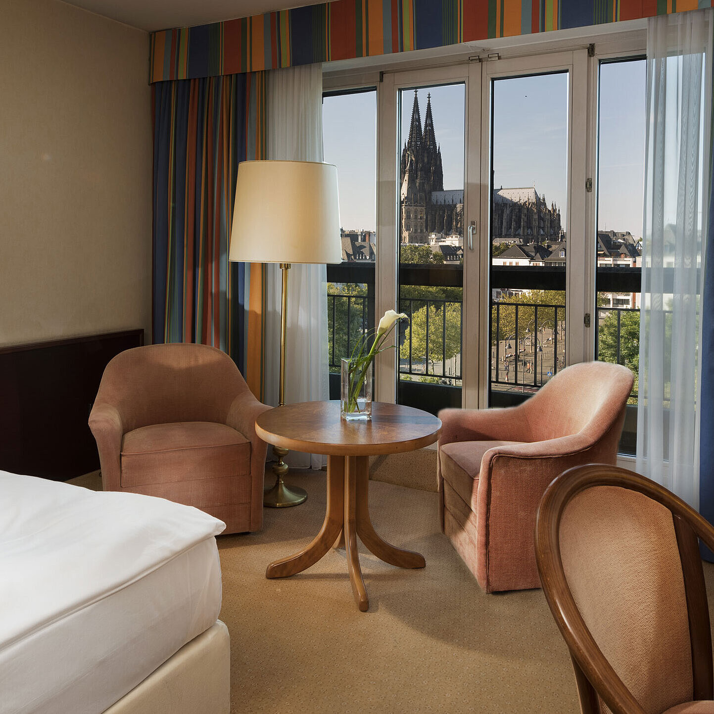 Superior-Zimmer im Maritim Hotel Köln mit Sitzbereich, komfortablem Bett und Blick auf den Kölner Dom.