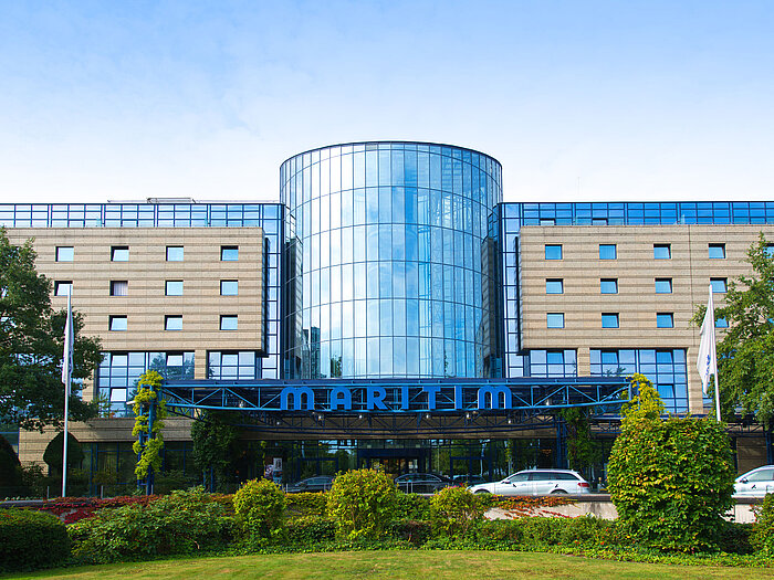 Außenansicht des Maritim Hotels Bonn mit moderner Glasfassade und gepflegter Gartenanlage im Vordergrund.