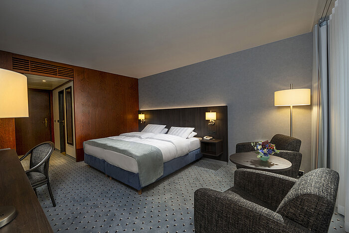 Modern eingerichtetes Classic Zimmer mit Schreibtisch, Fernseher, Sitzbereich und komfortablem Bett im Maritim Bremen.