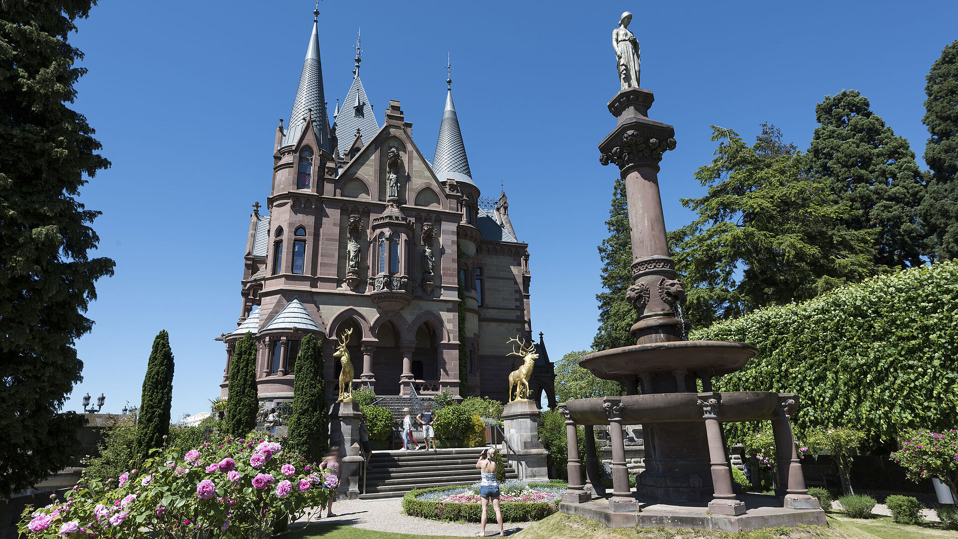 Schloss Drachenburg Das prachtvolle Schloss Drachenburg mit einem kunstvollen Brunnen und blühendem Garten.
