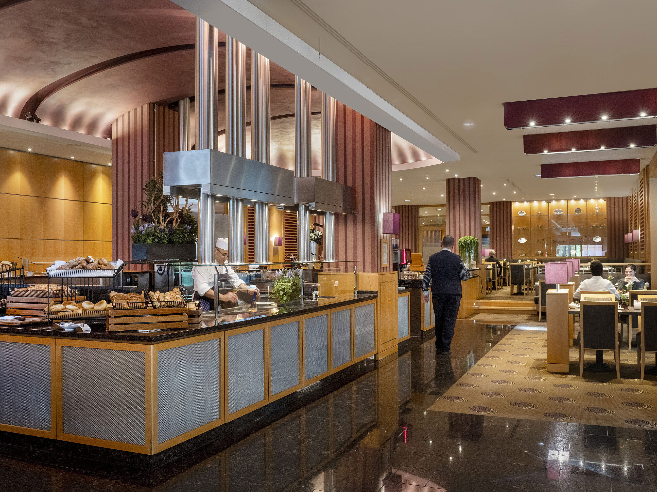Frühstücksbereich im Maritim Hotel Düsseldorf mit Live-Cooking-Station, frischen Backwaren und eleganter Einrichtung.