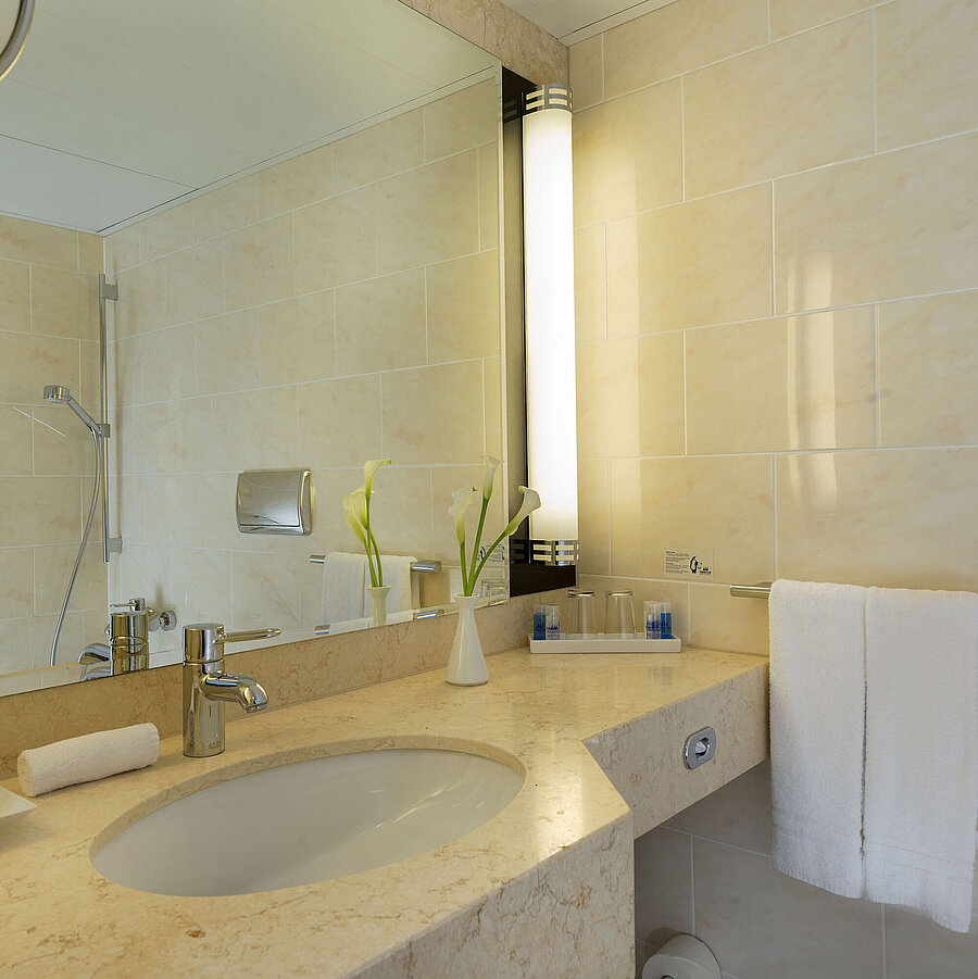 Badezimmer Modernes Badezimmer im Maritim Hotel Fulda mit Marmorwaschtisch, großer Spiegel und begehbarer Dusche.