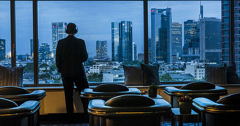  Gast genießt den Panoramablick auf die Skyline von Frankfurt in der Sky Lounge des Maritim Hotel Frankfurt.