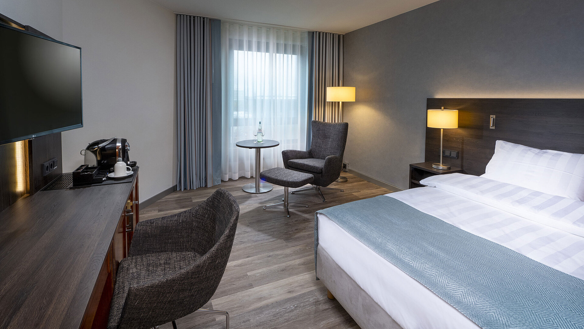 Modern eingerichtetes Superior Queen Zimmer mit Schreibtisch, Fernseher, Sitzbereich und komfortablem Bett im Maritim Bremen.