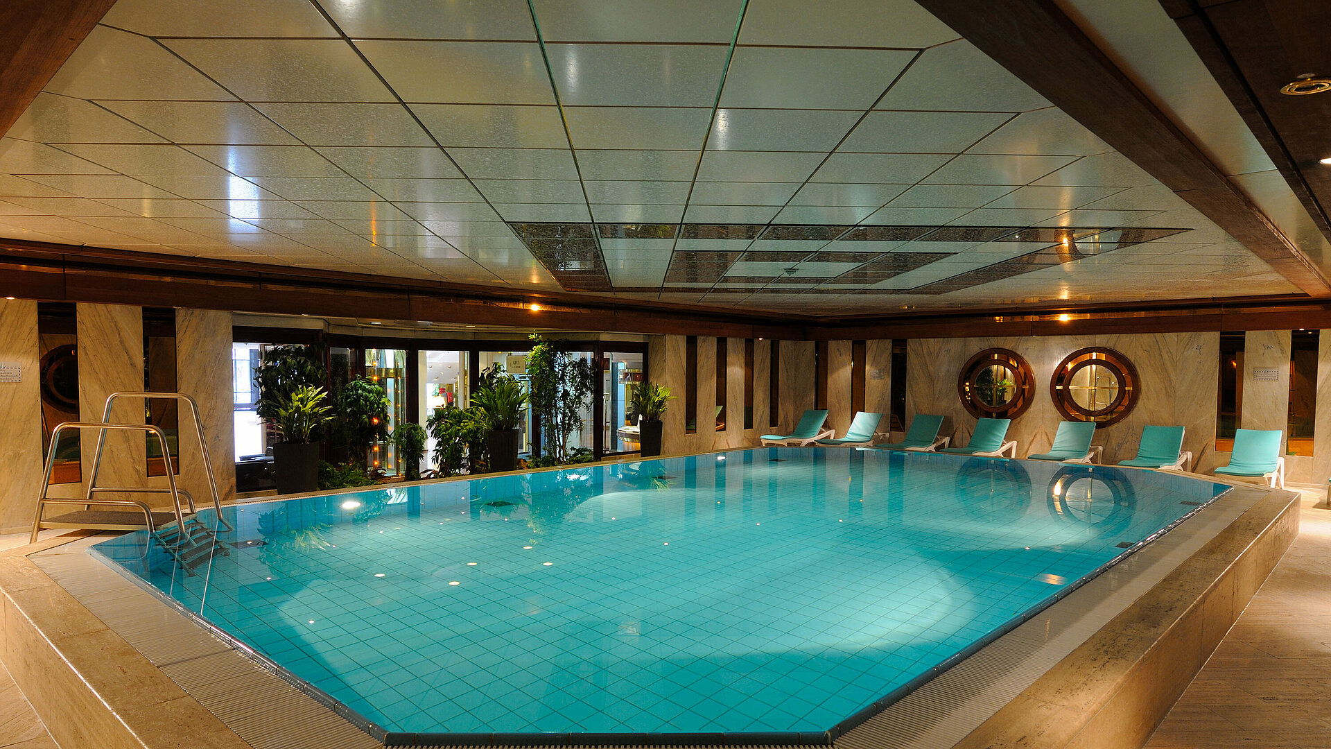 Innenpool im Maritim Hotel Köln mit Liegestühlen und Pflanzen für eine entspannende Atmosphäre.