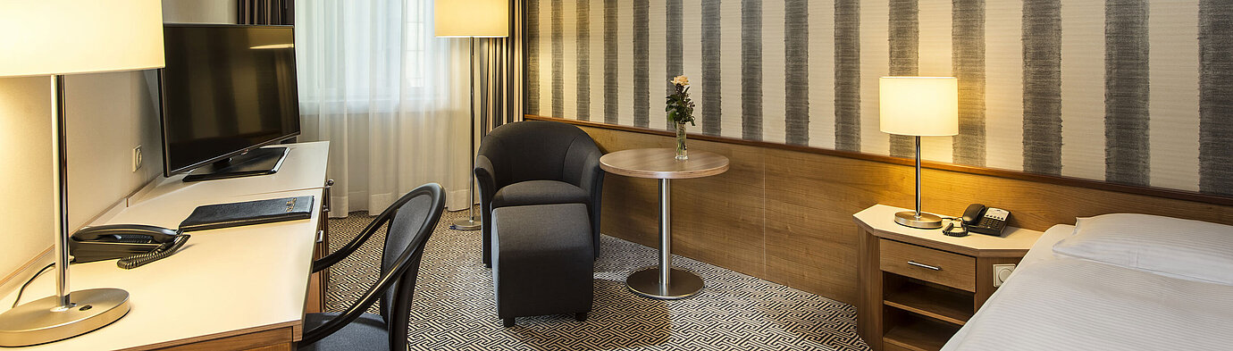 Schreibtisch mit TV und komfortabler Sitzmöglichkeit im Einzelzimmer des Maritim Hotel Stuttgart