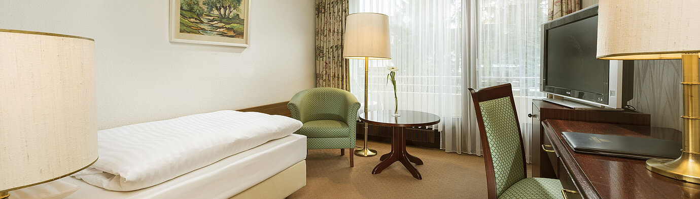 Classic Zimmer Einzelzimmer mit Schreibtisch, Sessel und Balkonzugang im Maritim Hotel Bad Salzuflen
