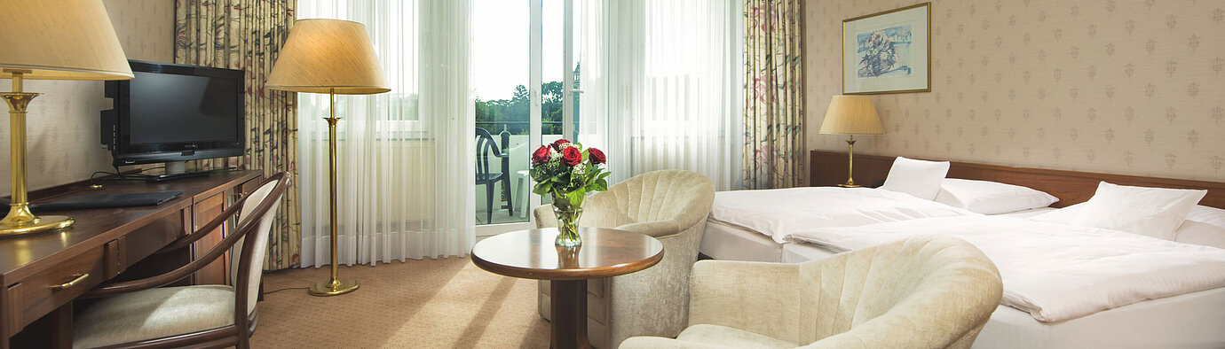 Helles Doppelzimmer mit Zugang zur Terrasse und Sitzgruppe im Maritim Hotel Bad Wildungen