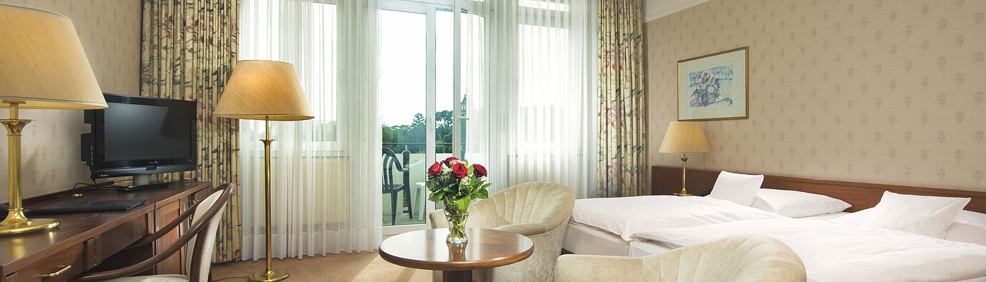 Helles Doppelzimmer mit Zugang zur Terrasse und Sitzgruppe im Maritim Hotel Bad Wildungen