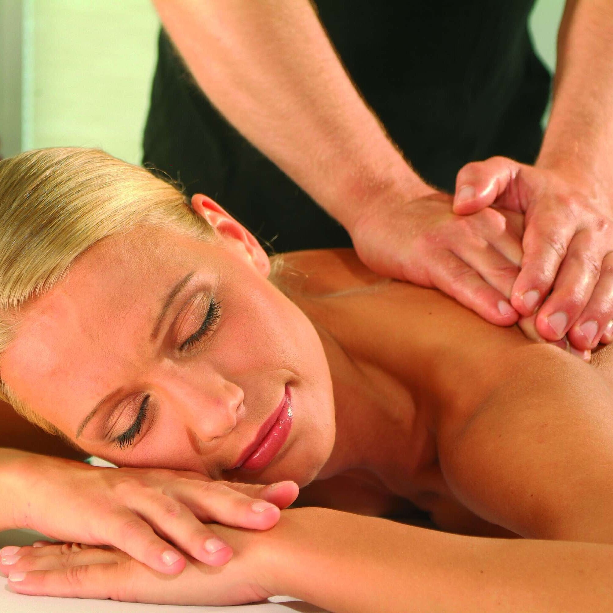 Frau genießt eine entspannende Massage im Maritim Hotel Timmendorfer Strand, Wellness und Erholung in angenehmer Atmosphäre.