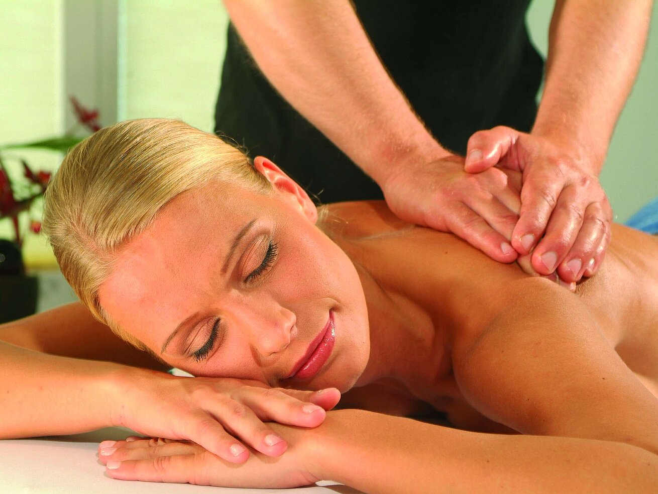 Massage Frau genießt eine entspannende Massage im Maritim Hotel Timmendorfer Strand, Wellness und Erholung in angenehmer Atmosphäre.