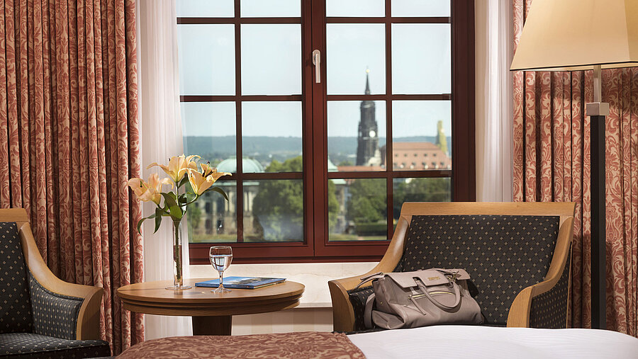 Sitzbereich im Superior Zimmer des Maritim Hotel Dresden mit Blick aus dem Fenster auf die historische Altstadt.