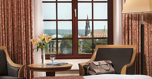 Sitzbereich im Superior Zimmer des Maritim Hotel Dresden mit Blick aus dem Fenster auf die historische Altstadt.