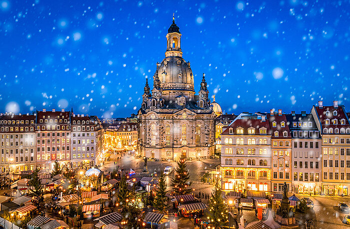 Weihnachtsmarkt am Neumarkt in Dresden mit der beleuchteten Frauenkirche im Schnee