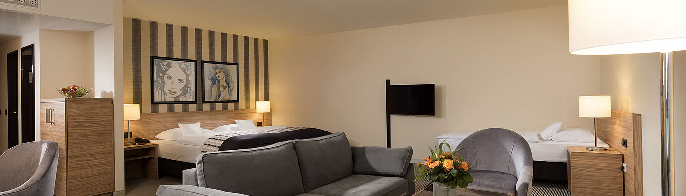 Geräumiges Familienzimmer im Maritim Hotel Königswinter mit Sitzecke und stilvollem Design.