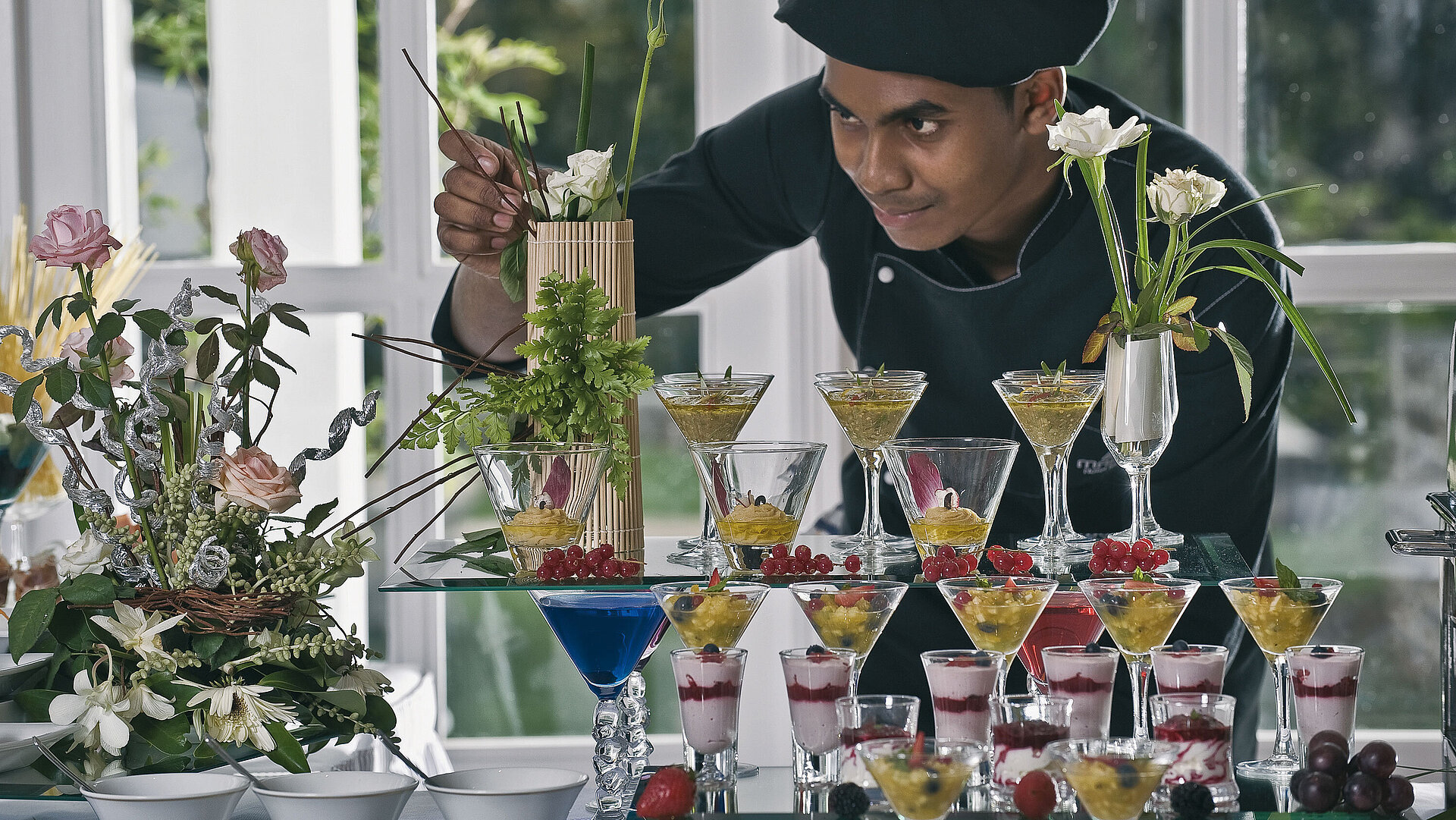 Fine Dining Restaurant "Château Mon Désir" Koch dekoriert kunstvolle Desserts und Gläser bei elegantem Dessertbuffet