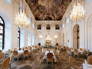 Eleganter Apollo Saal im Maritim Hotel Fulda mit Kronleuchtern, Freskendecke und stilvoll gedeckten Tischen.