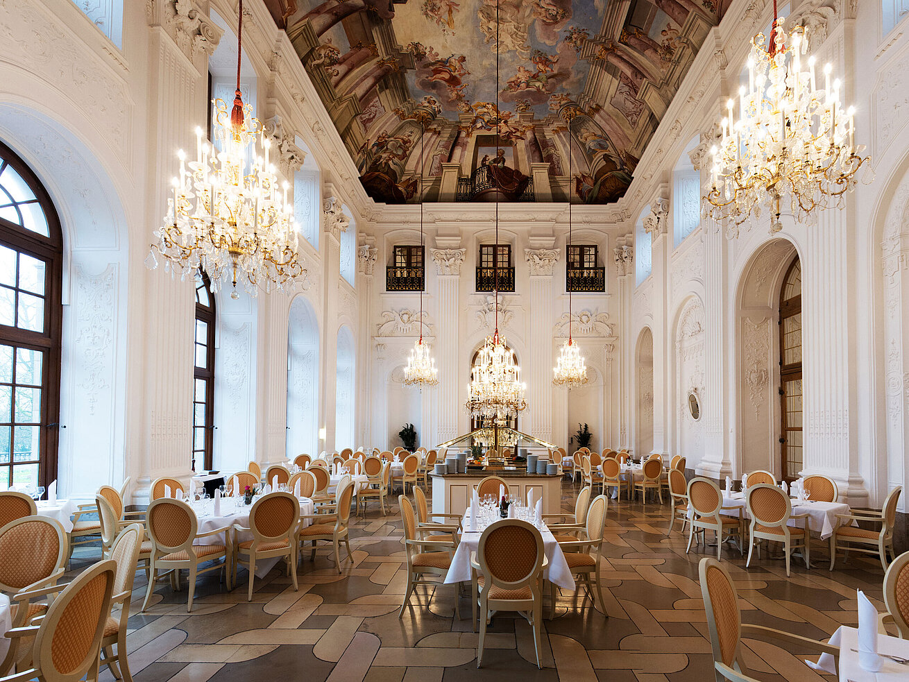 Eleganter Apollo Saal im Maritim Hotel Fulda mit Kronleuchtern, Freskendecke und stilvoll gedeckten Tischen.