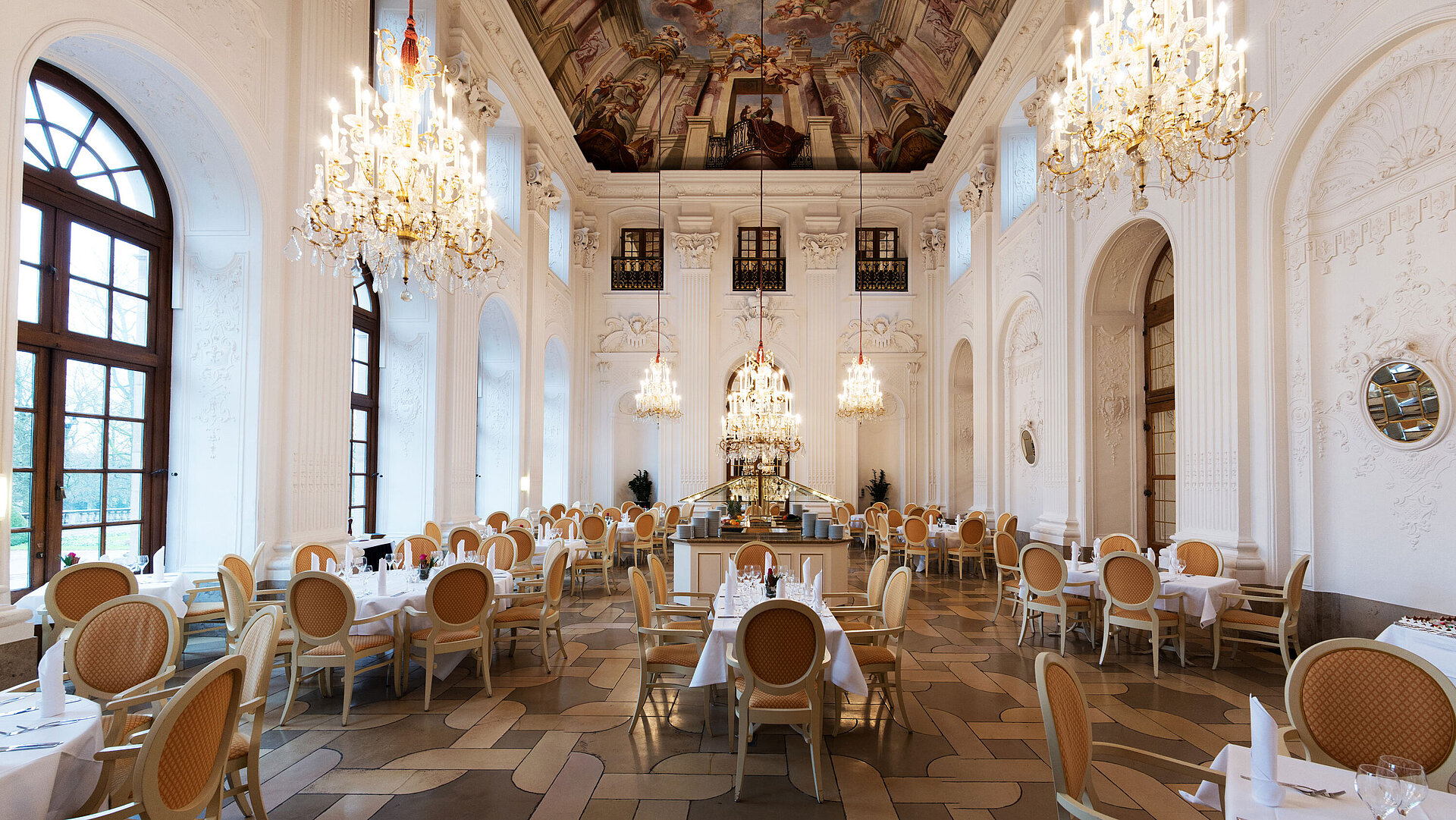 Eleganter Apollo Saal im Maritim Hotel Fulda mit Kronleuchtern, Freskendecke und stilvoll gedeckten Tischen.