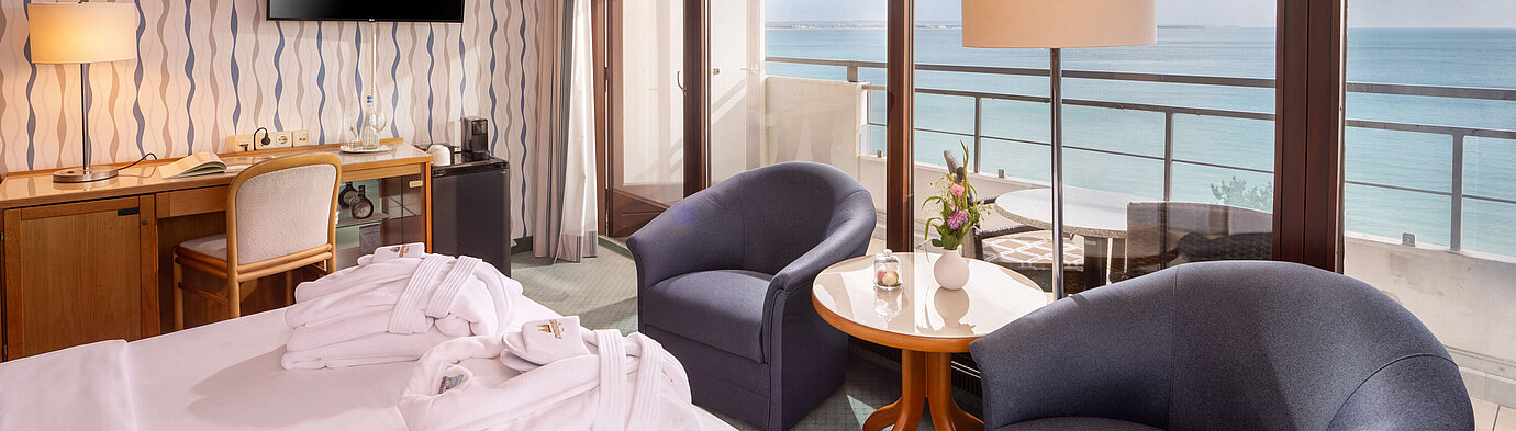 SuperiorPlus Zimmer Seeseite SuperiorPlus Zimmer Seeseite mit Sitzecke, Doppelbett und Balkon mit Blick auf die Ostsee