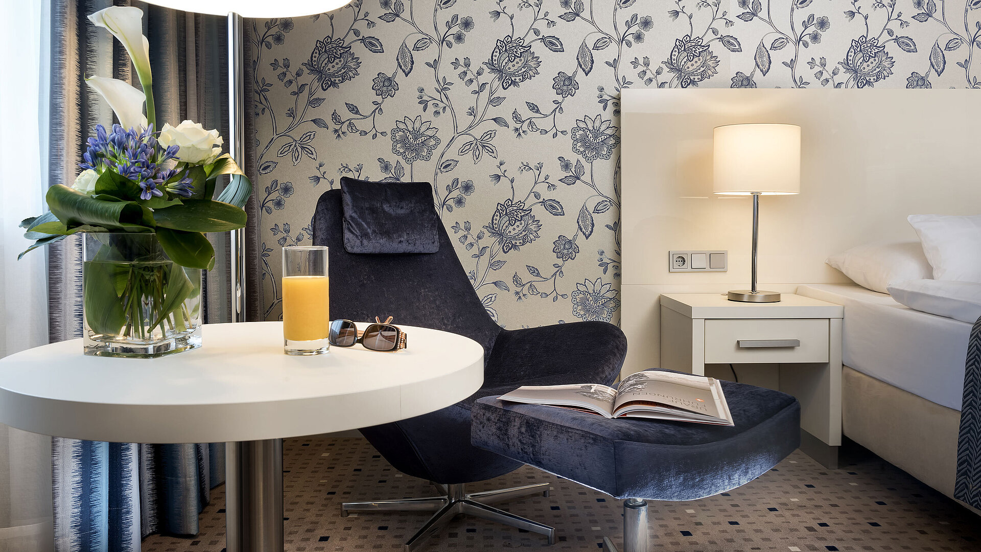 Superior Zimmer im Maritim Hotel Bonn mit stilvoller Einrichtung, gemütlichem Sessel, Blumenarrangement und moderner Beleuchtung