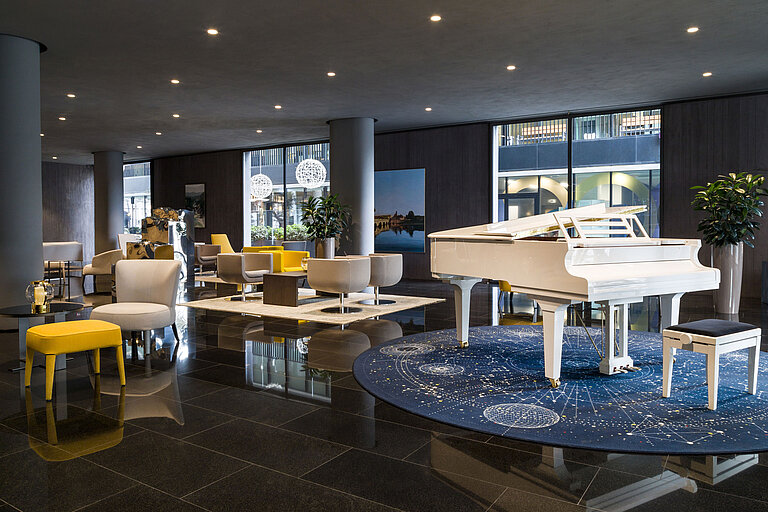 Stilvolle Lobby mit weißem Flügel und modernen Sitzbereichen im Maritim Hotel Plaza Tirana