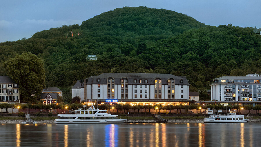 Das Maritim Hotel Königswinter bei Nacht mit stimmungsvoller Beleuchtung und Blick auf den Rhein.