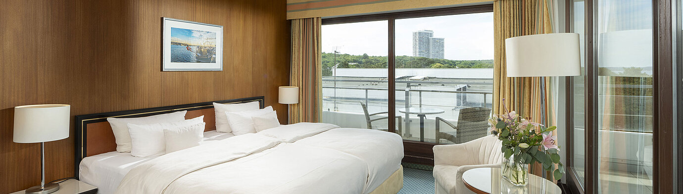 Geräumige Familiensuite im Maritim Seehotel Timmendorfer Strand mit Balkon, Meerblick und gemütlicher Sitzecke.