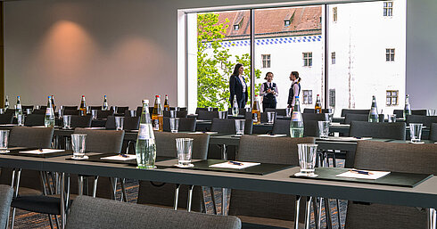 Drei Mitarbeitende im Tagungsraum des Maritim Hotel Ingolstadt besprechen letzte Details vor einem Event.