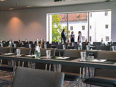 Drei Mitarbeitende im Tagungsraum des Maritim Hotel Ingolstadt besprechen letzte Details vor einem Event.