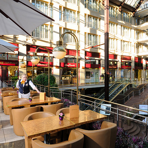 Café Heumarkt im Maritim Hotel Köln mit Sitzgelegenheiten und Servicepersonal in stilvoller Atmosphäre.