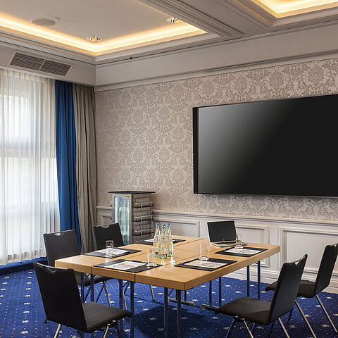 Tagungsraum im Maritim Hotel Würzburg mit moderner Ausstattung und großem Bildschirm.