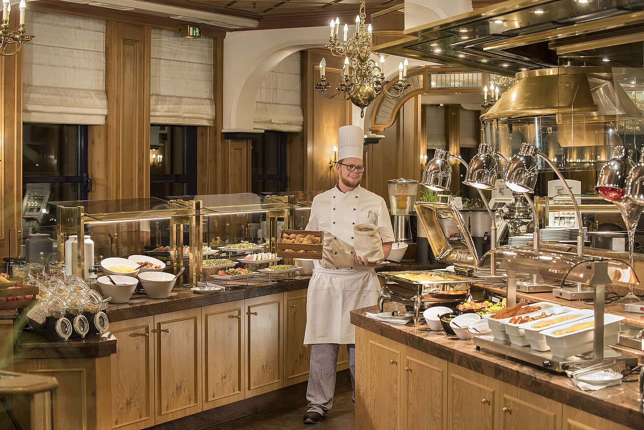 Frühstücksbuffet im Restaurant "Rôtisserie" im Maritim Hotel Bonn mit einer Auswahl an Speisen und einem freundlichen Koch.